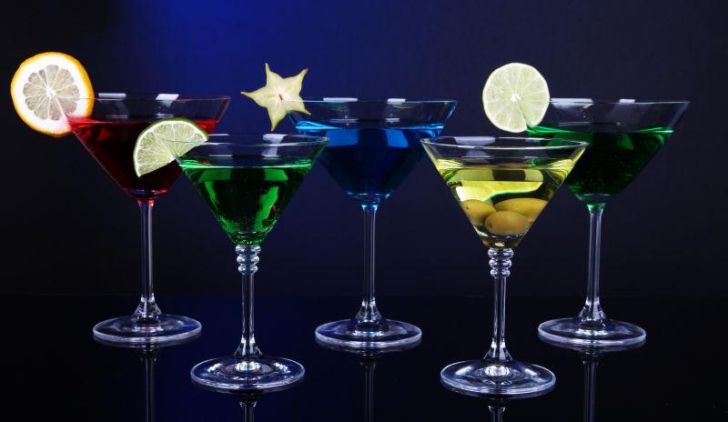 深蓝色背景下马蒂尼酒杯中的酒精鸡尾酒