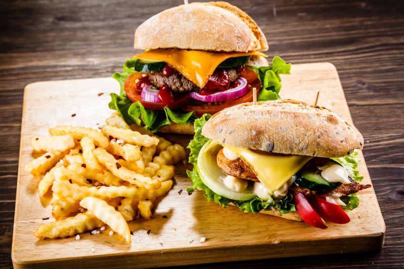 木板上的两个汉堡和薯条