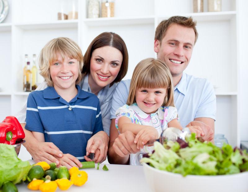快乐的年轻家庭一起在厨房做饭
