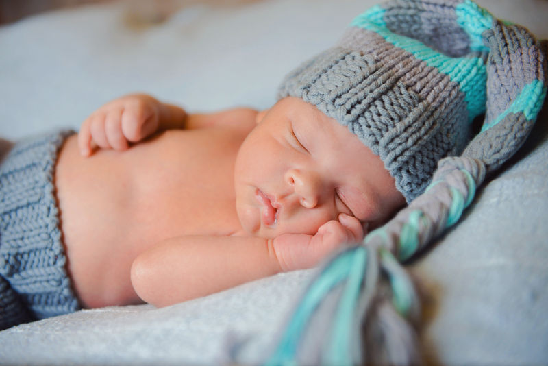 戴着灰色长帽入睡的宝宝