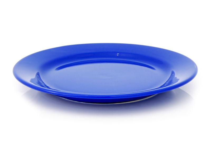 白色背景上的一块蓝色的盘子