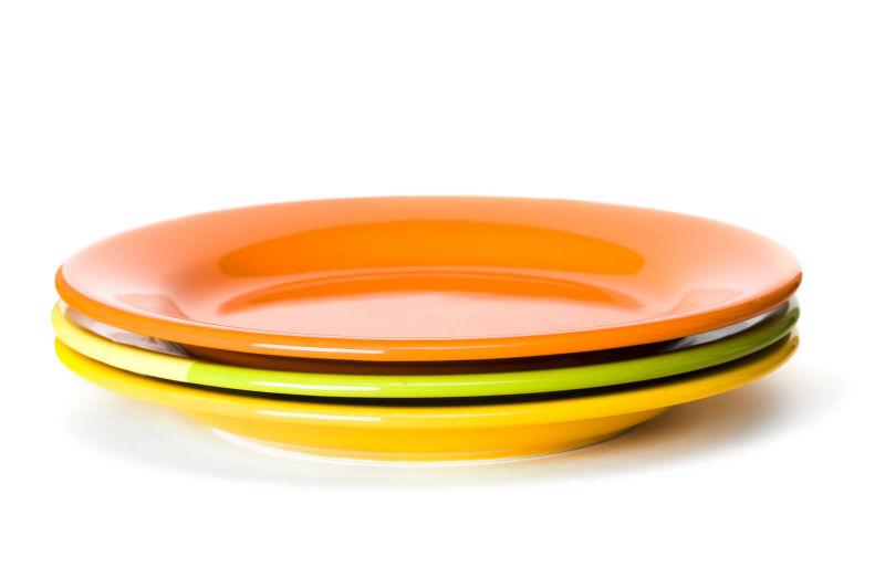 白色背景中的橙色和绿色餐盘
