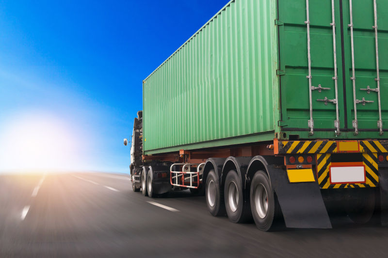 路面上行驶的绿色厢式货车