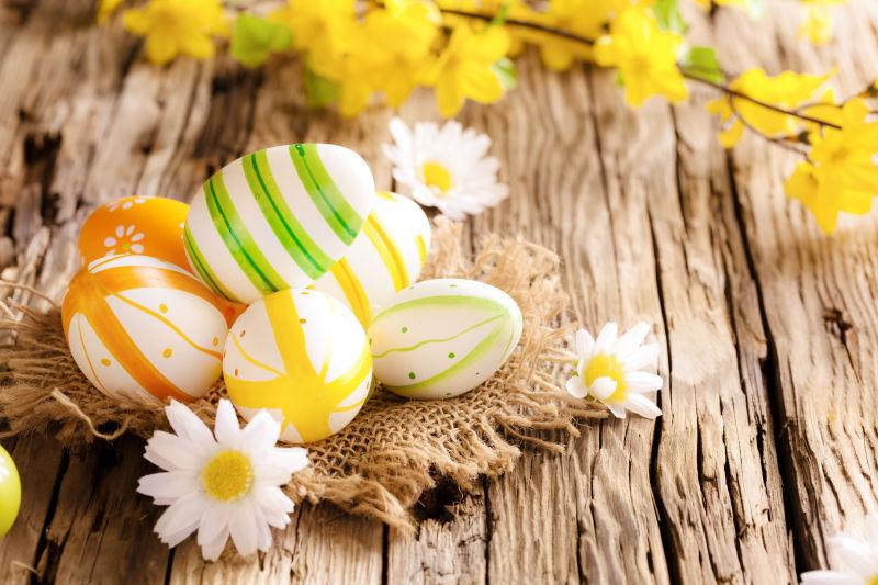 老旧木桌上的复活节彩蛋和花朵