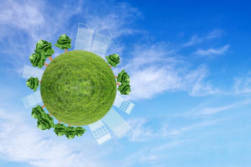 概念微型地球仪在天空背景下绘制树木纸和绘制城市的环境