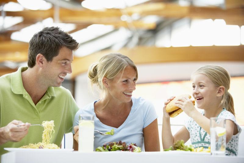 看着女儿开心吃汉堡的父母