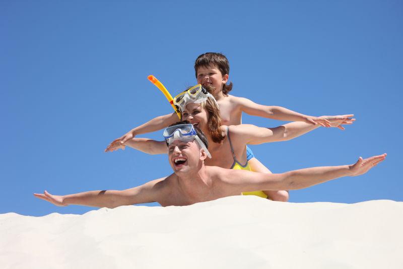 沙滩上玩飞行游戏的家庭