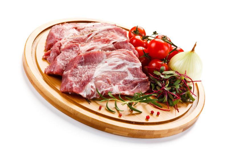 圆的菜板上放着生猪肉
