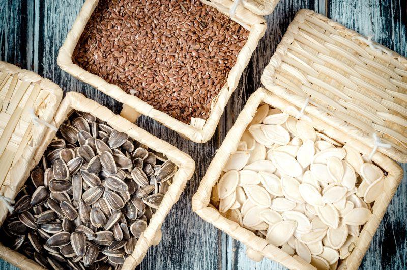 葵花籽与亚麻籽和南瓜籽在竹篮上的木板上