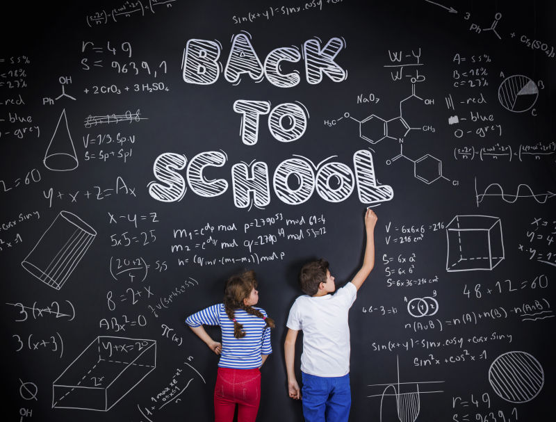 可爱的男孩和女孩在黑板上嬉戏玩耍