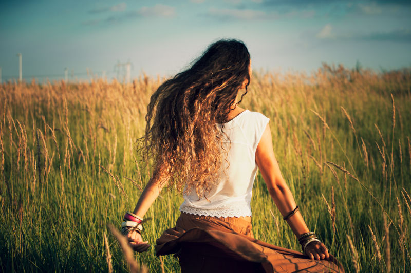 年轻女子奔跑在夏日的草地上