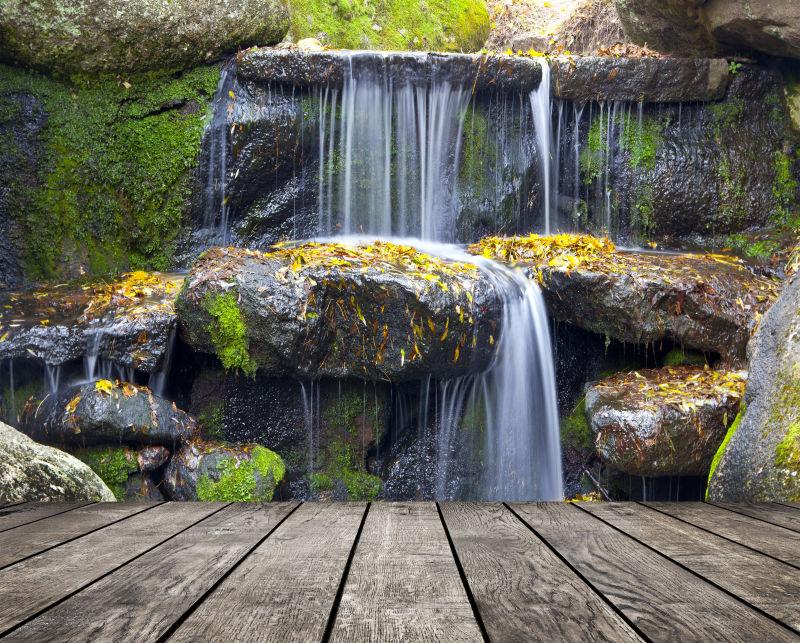 瀑布背景前的木制纹理桌子