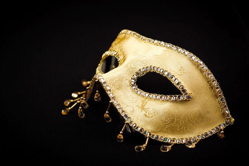 黑色背景中闪亮的金色面具