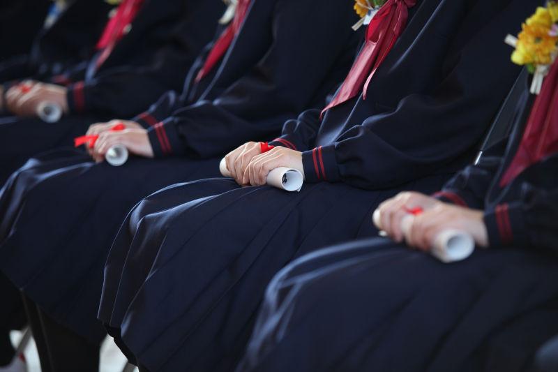 一排手拿文凭合影的毕业生