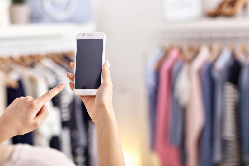 服装店女性手持的智能手机