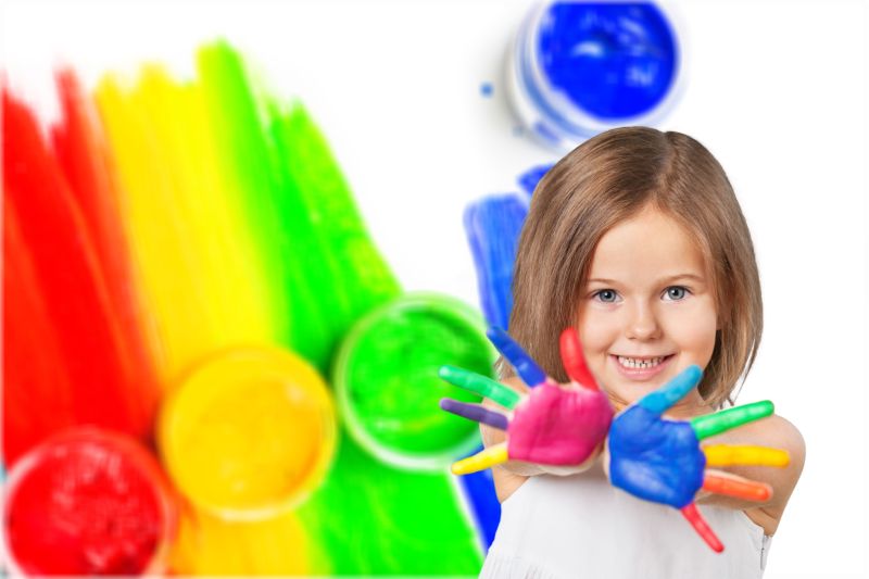 彩色背景下开心的玩颜料小女孩