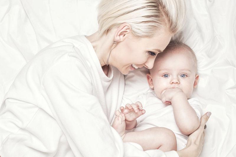 母亲在床上抱着她的孩子