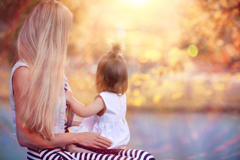 女孩坐在母亲的腿上