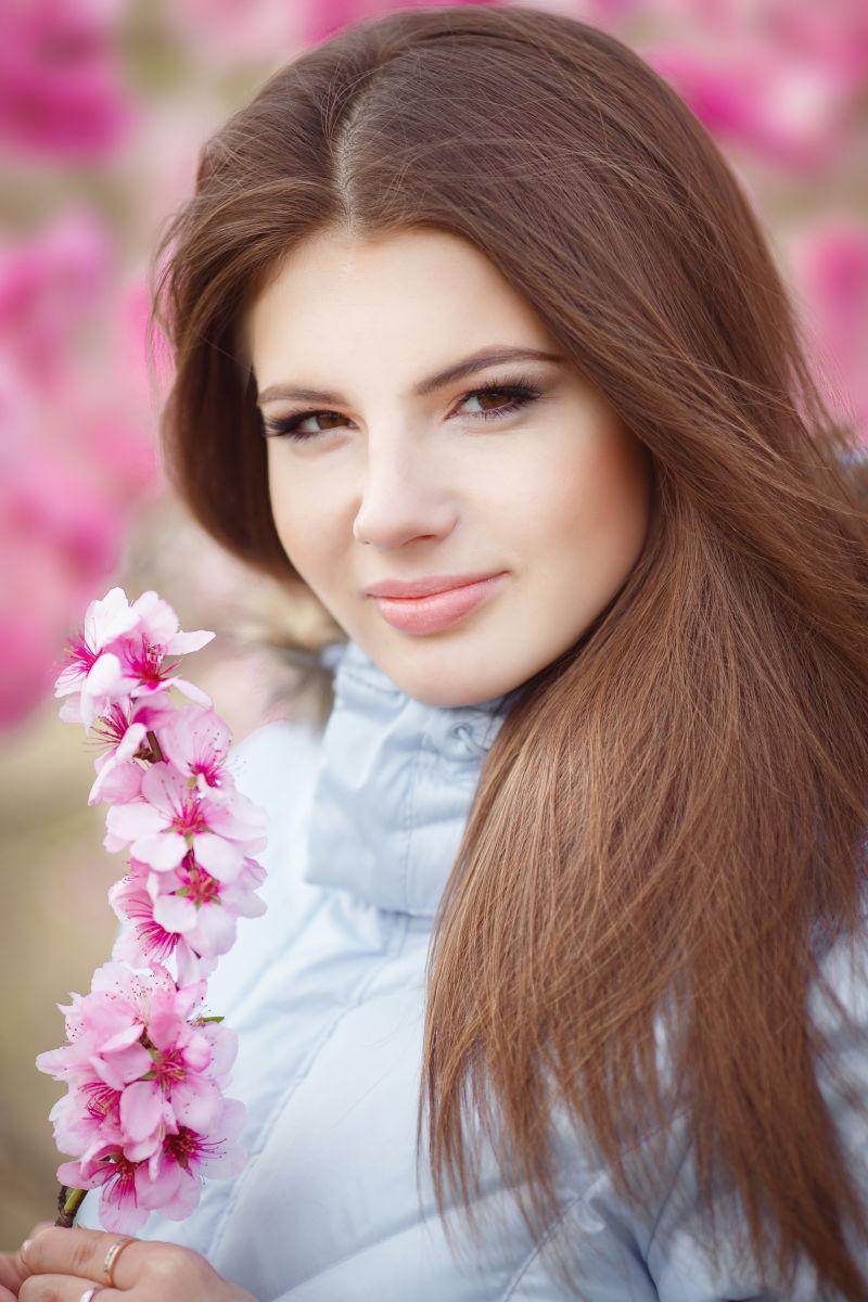 拿着粉色花的可爱的女孩