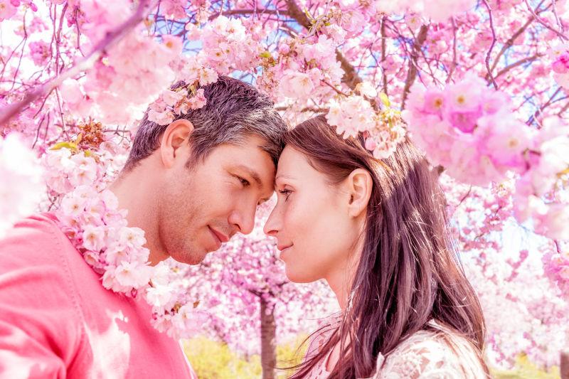 在开花的树林中坠入爱河的幸福情侣