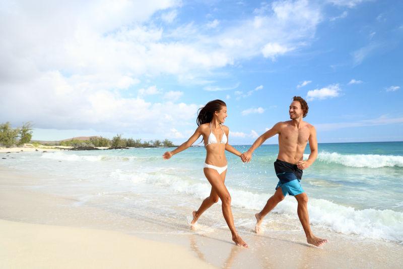 海滩度假的夫妇在假日跑步