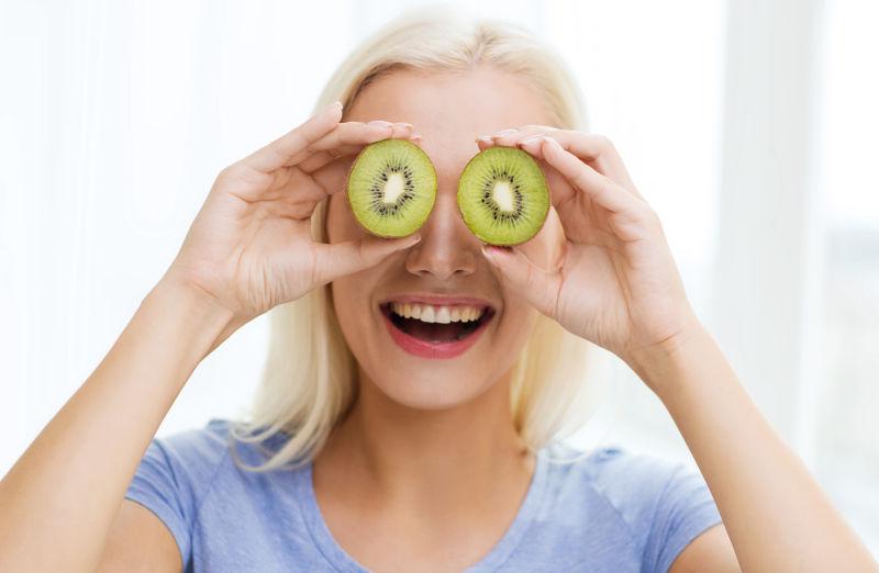 快乐的女人玩弄猕猴桃切片