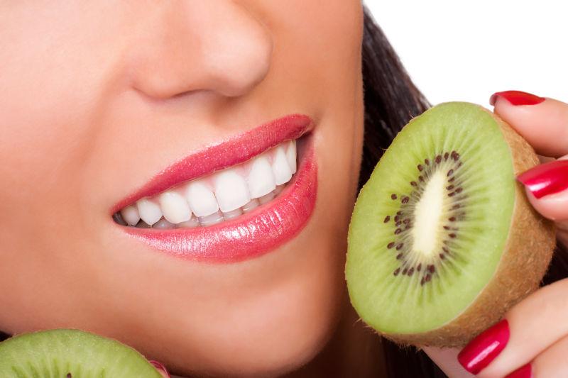 美女的脸和多汁的猕猴桃