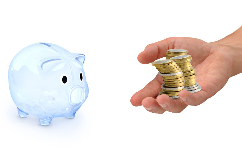 透明的小猪存钱罐和手心里的钱