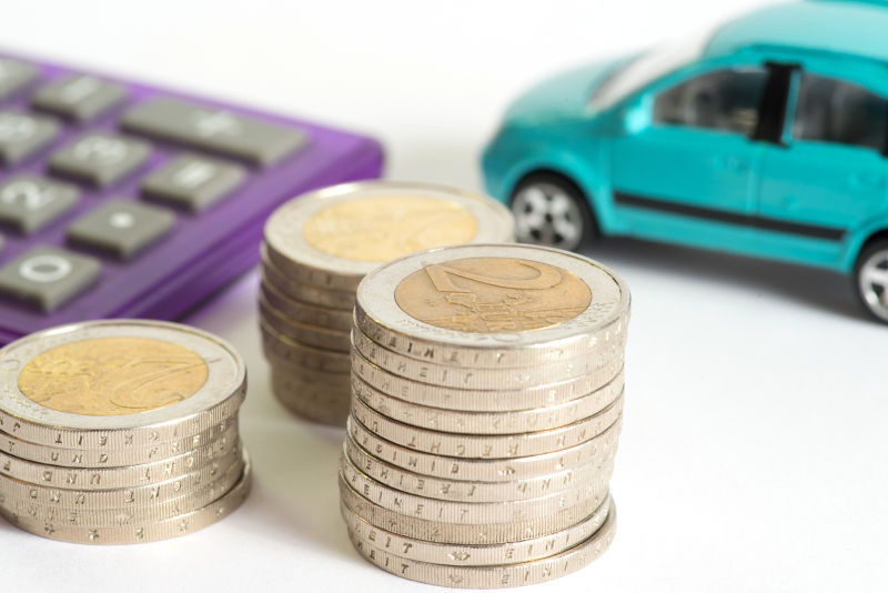 白色背景上的金币和计算器汽车模型