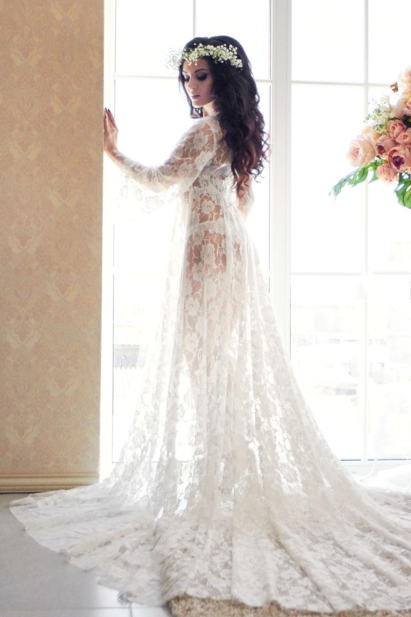 窗户边穿着白色蕾丝婚纱的新娘