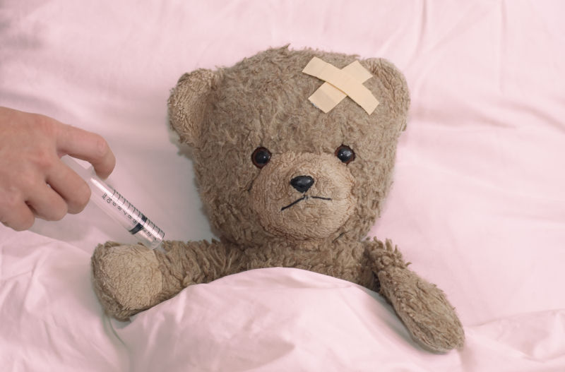 给病床上的泰迪熊打针