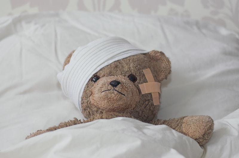 白色病床上的泰迪熊