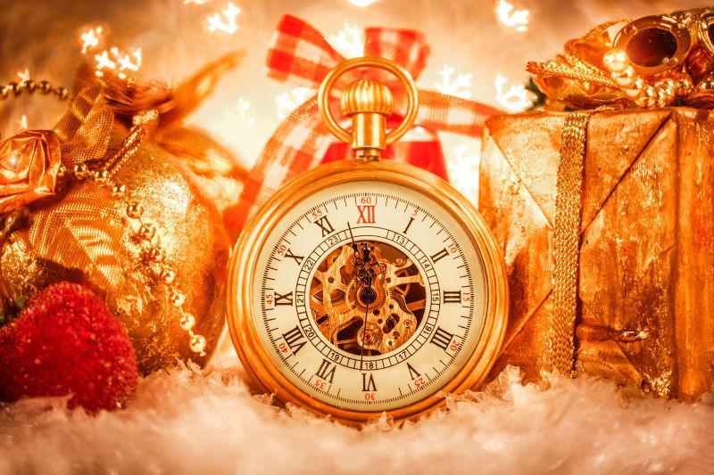 白色背景上的圣诞节的金色包装礼物盒子和金色的怀表