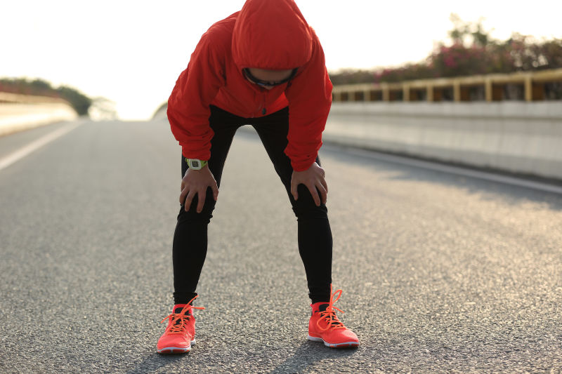 在城市道路上跑步后休息的跑步者