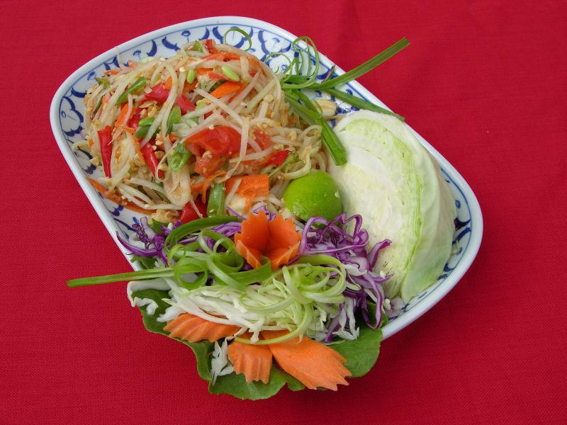 红色背景下放在餐盘里得蔬菜等美食