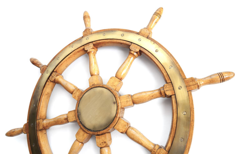 白色背景下的老式木制船舶方向盘