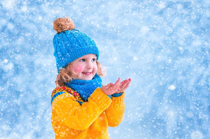 可爱的小女孩在接天上的飘雪