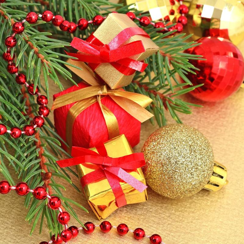 金色背景上的金色和红色的礼品和圣诞装饰品