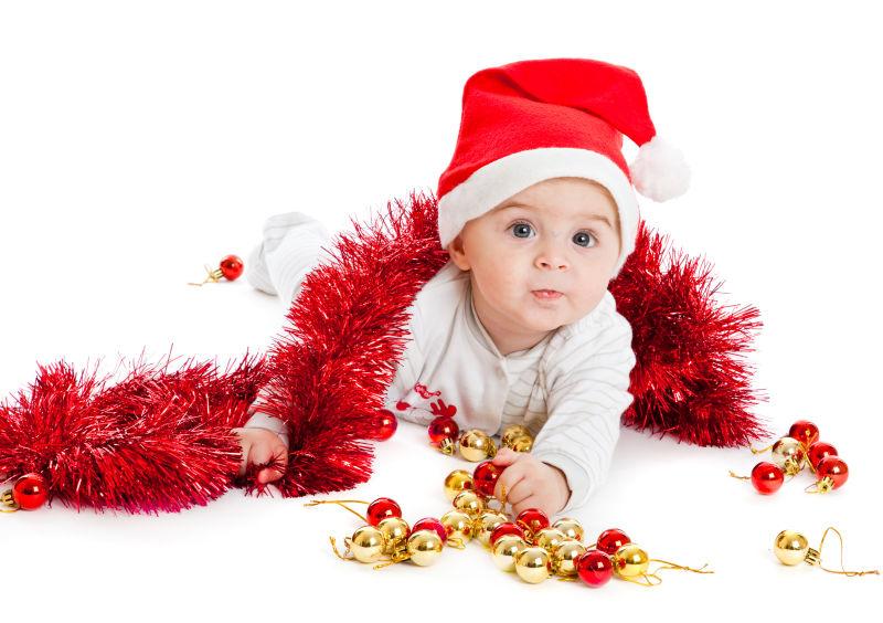 一个婴儿坐在地板上做圣诞装饰