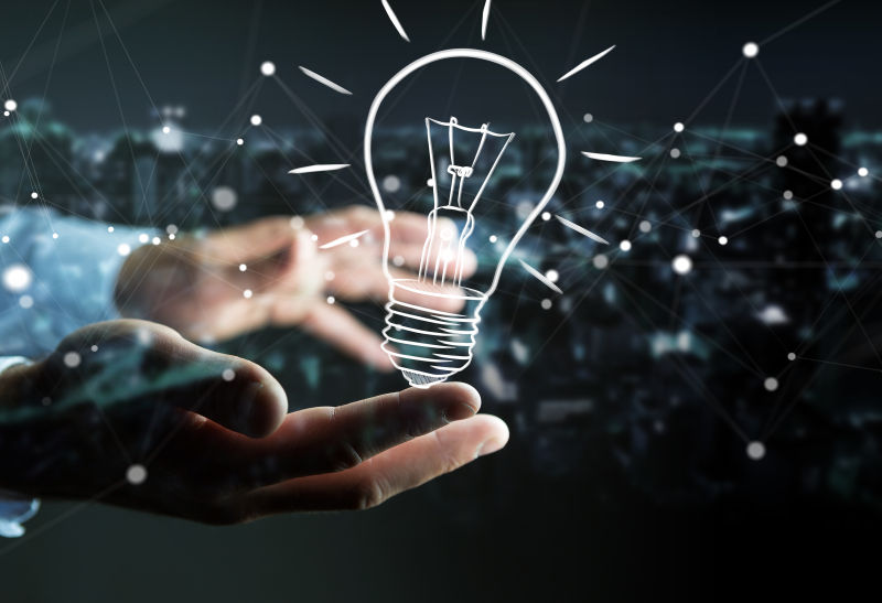 商人在模糊背景下手持灯泡