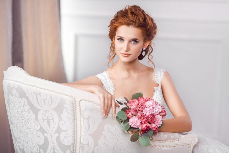 新娘穿着漂亮的礼服坐在沙发上