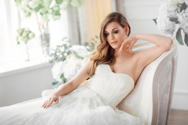 沙发上穿漂亮婚纱的美丽新娘