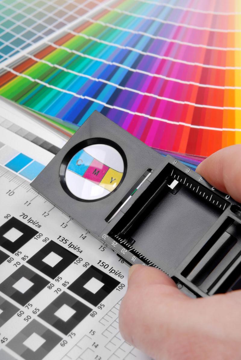 拿着放大镜查看色卡试纸的男人