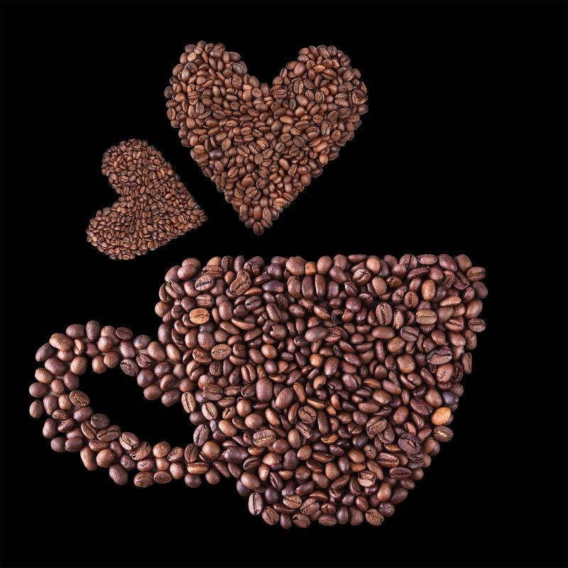黑色背景下的摆成心形的咖啡豆
