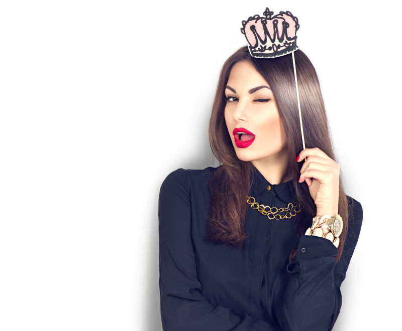 白色背景上拿着纸质皇冠的性感模特