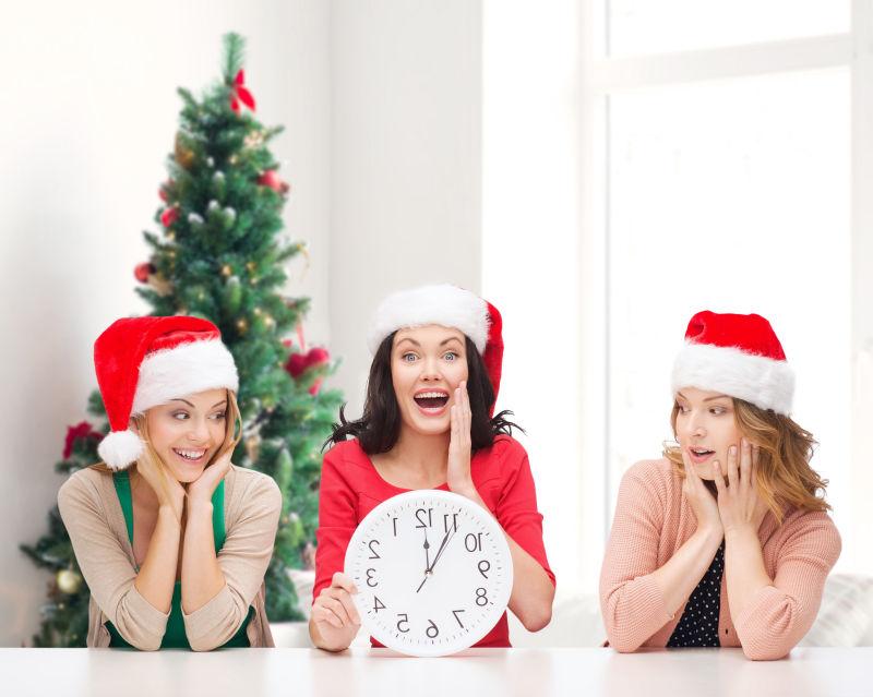 白色背景下戴着圣诞老人帽子的微笑女人