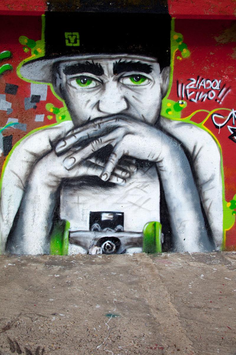 墙壁上戴着帽子思考的少年的涂鸦