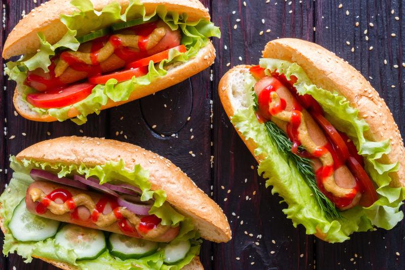 木桌上的三个热狗