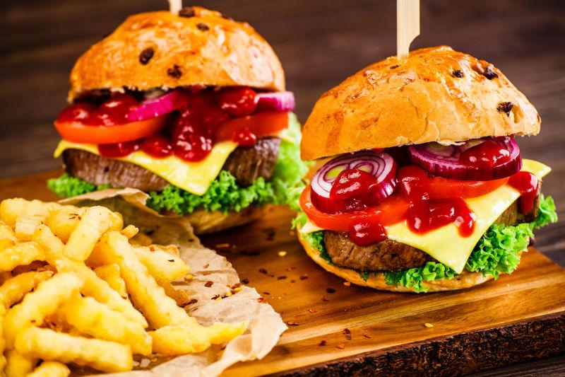 桌子上的两个牛肉汉堡和薯条