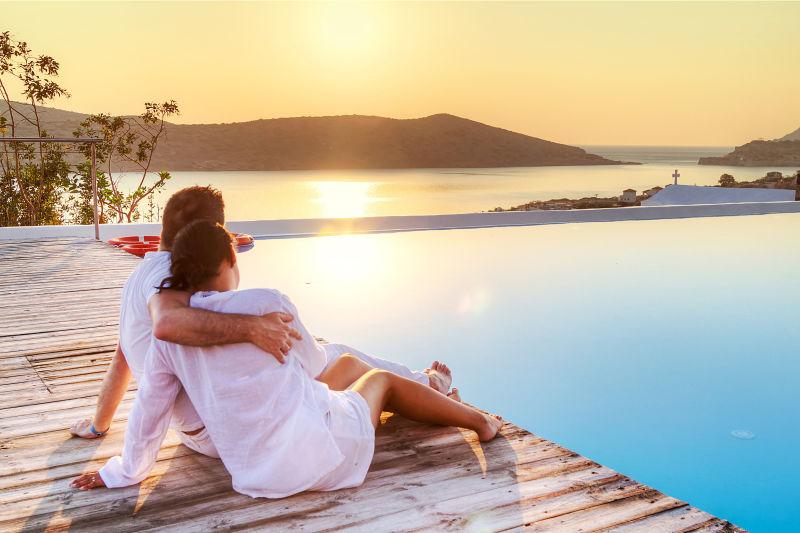 夕阳下坐在海边的夫妇